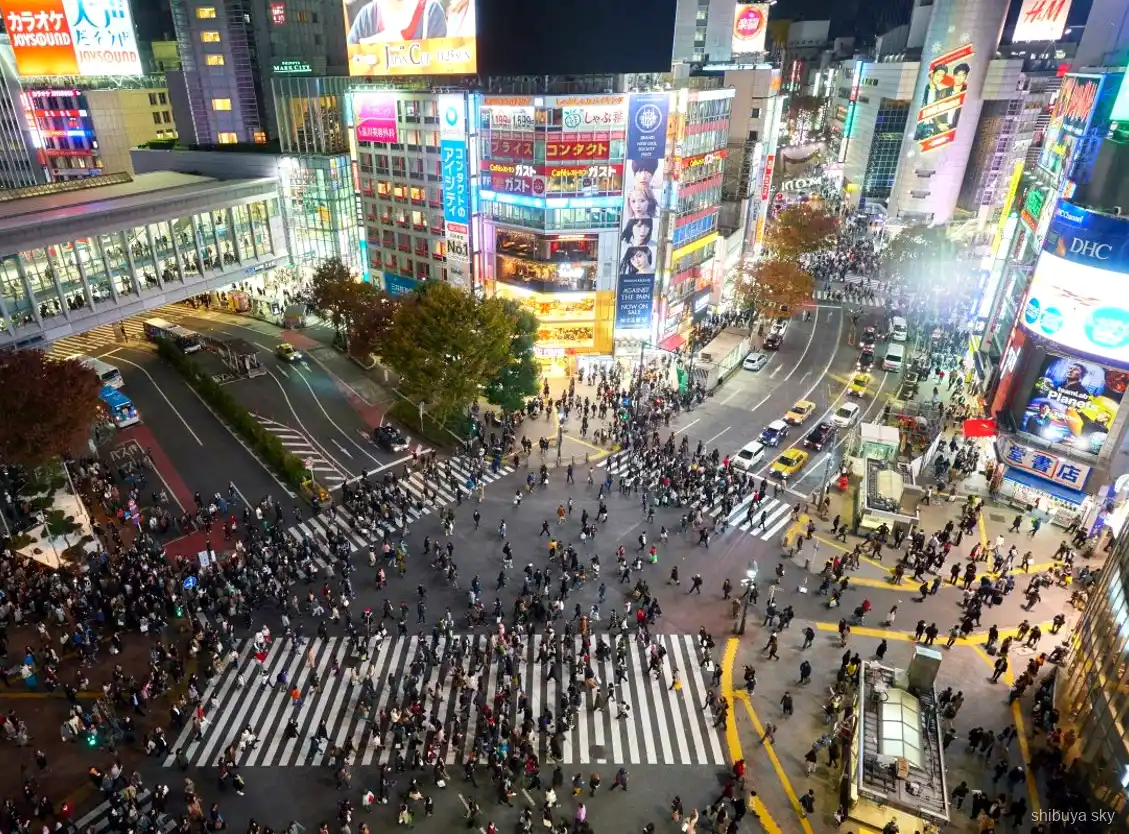 Shibuya Sky Nachttour, Guide und Besucher in den Neonstraßen